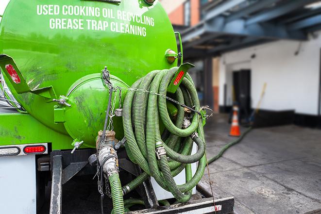 a vacuum truck pumping out a large underground grease trap in Bay Harbor Islands, FL